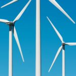 white wind turbines under the clear blue sky