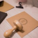 wooden stamp and invitation card on white table