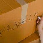 crop person packing box with fragile items
