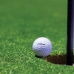 titrist golf ball near golf hole