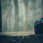 black half faced helmet on gray concrete wall