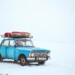 blue sedan on snow at daytime