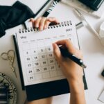 a person writing on a desk calendar