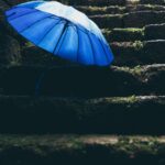 blue umbrella on black stairs