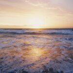 photo of ocean waves near seashore during sunset