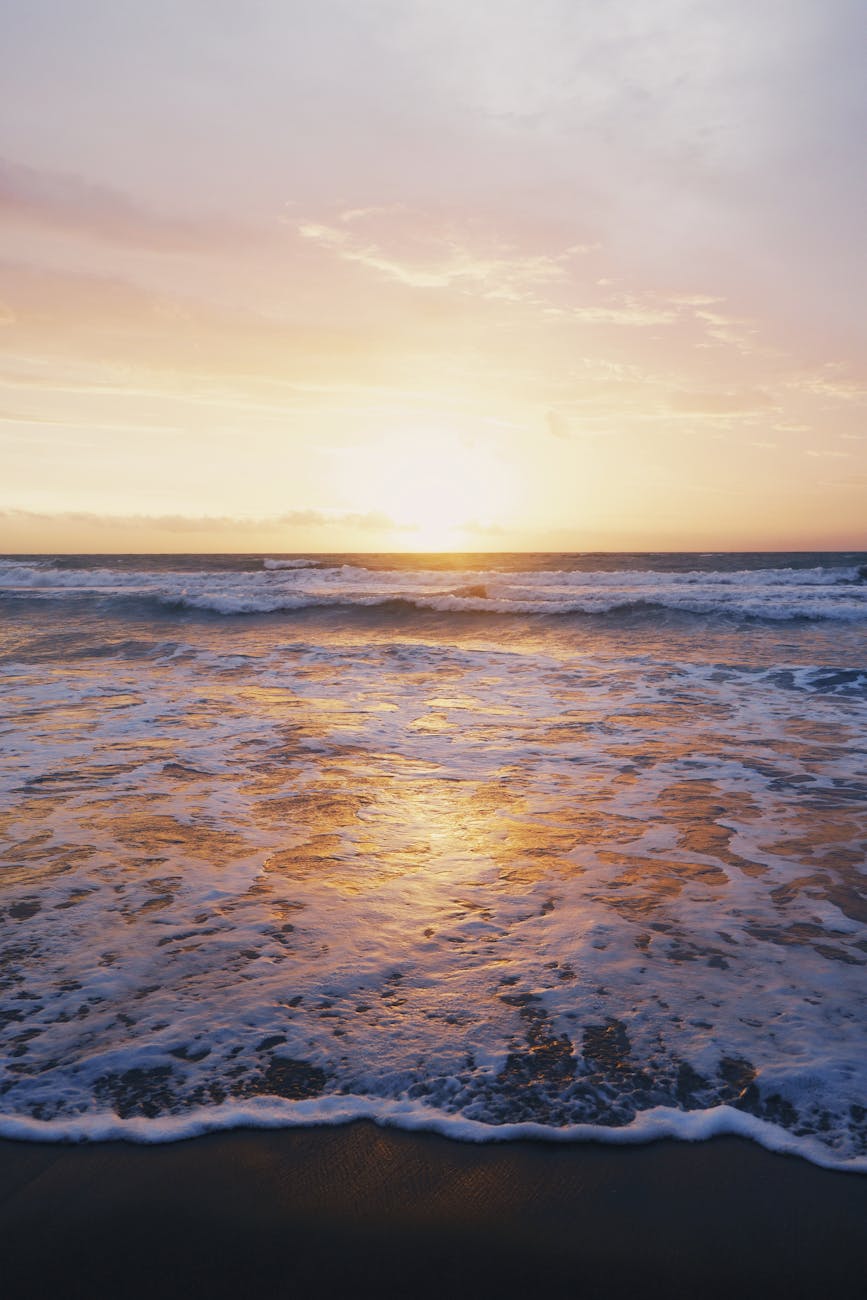 photo of ocean waves near seashore during sunset